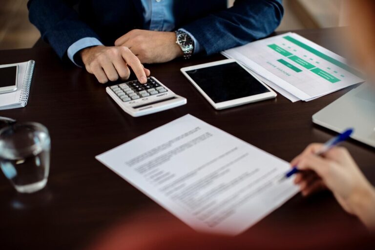 closeup-real-estate-agent-using-calculator-while-his-client-is-signing-contract_637285-10892